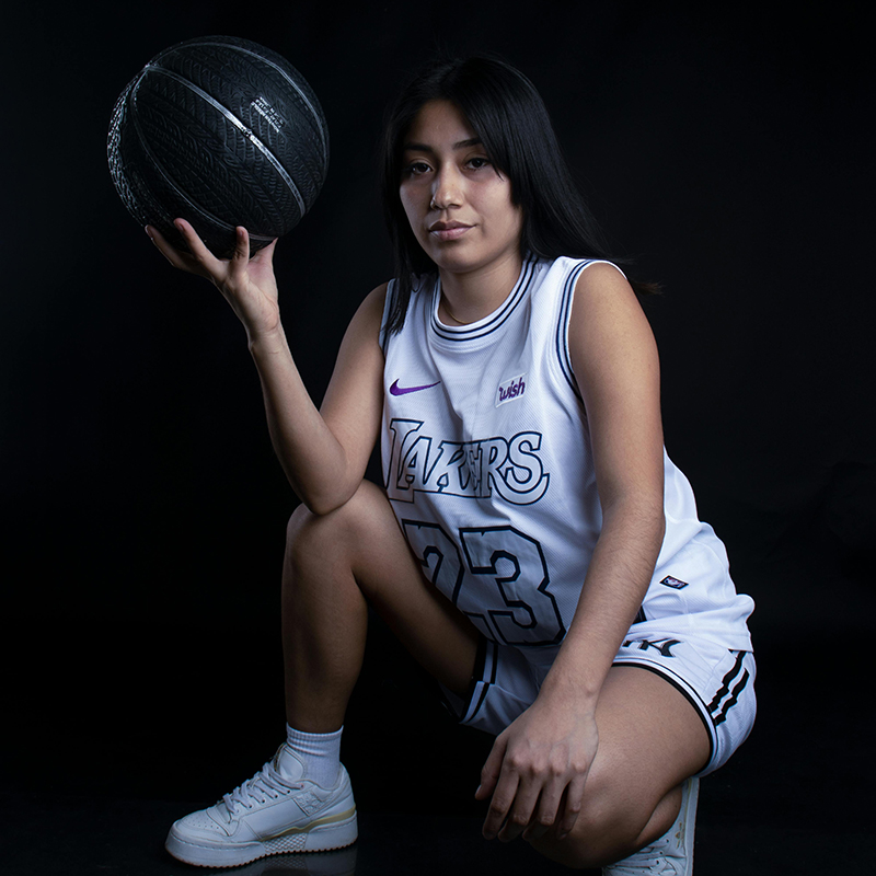 girl kneeling holding basketball