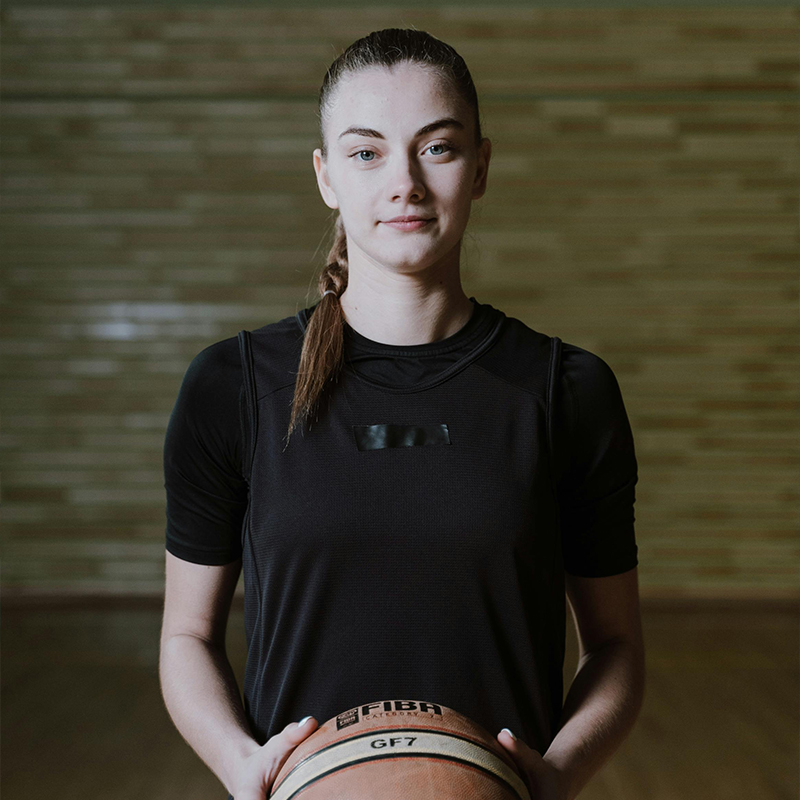 girl kneeling holding basketball