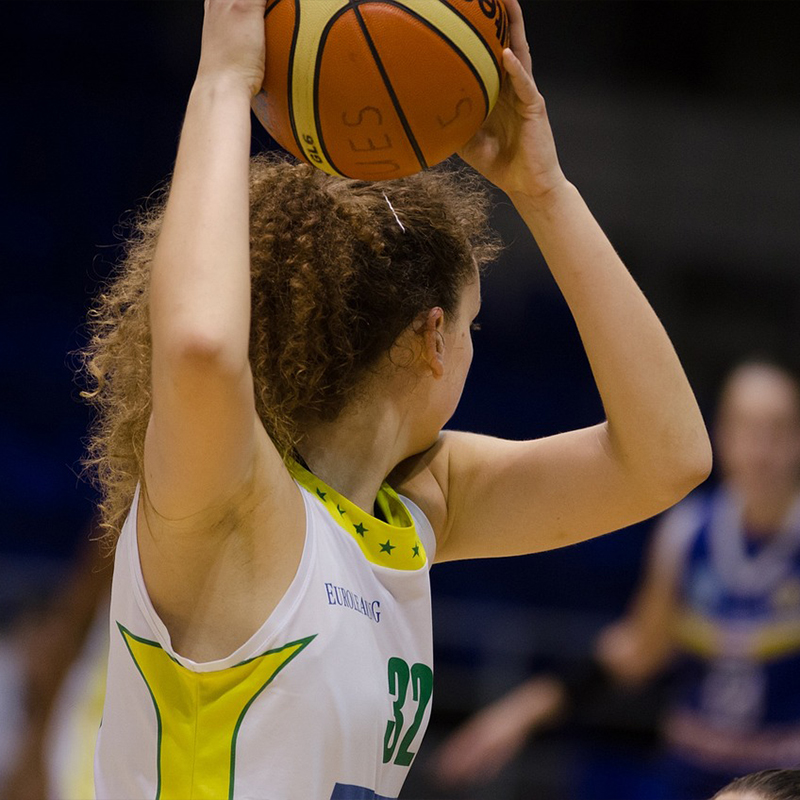 girl kneeling holding basketball