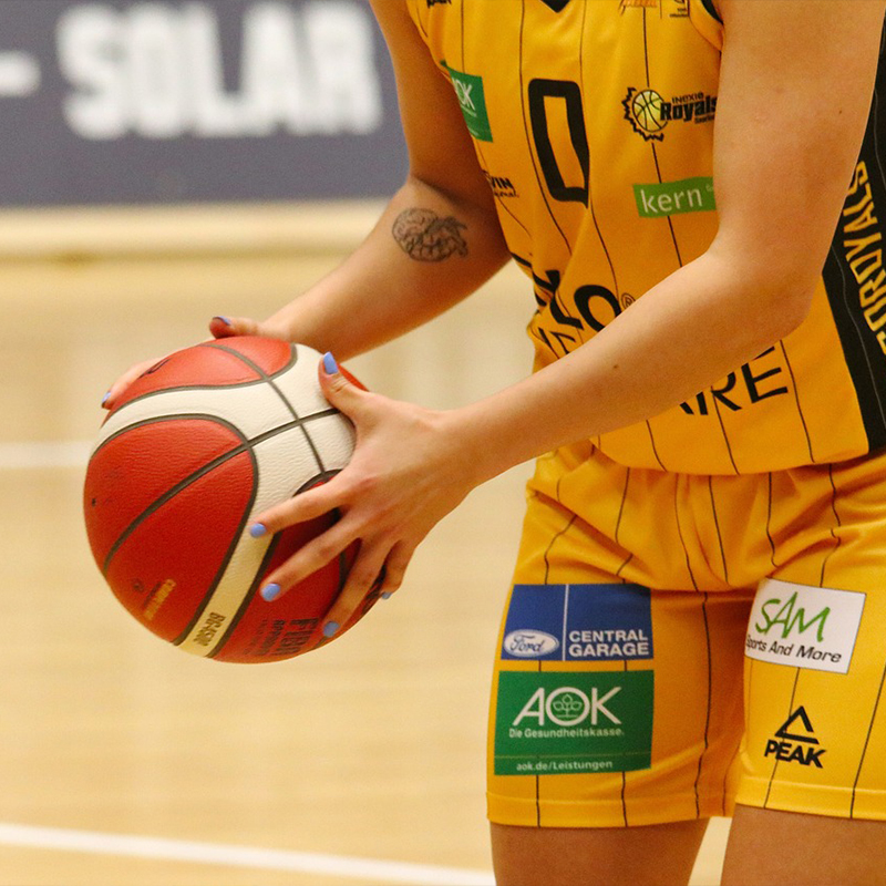 girl kneeling holding basketball