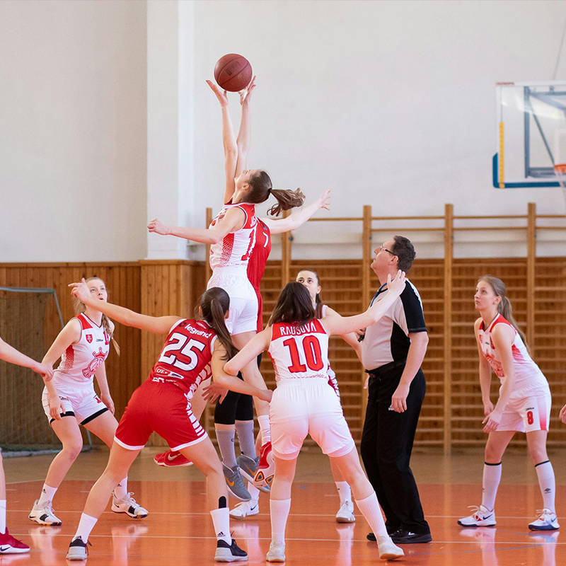 girl kneeling holding basketball